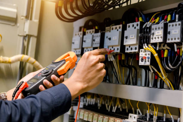 Electrician engineer work  tester measuring  voltage and current of power electric line in electical cabinet control.